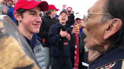 young man in a make america great again hat